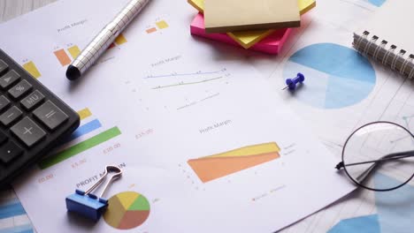gráfico financiero, calculadora y bloc de notas en la mesa