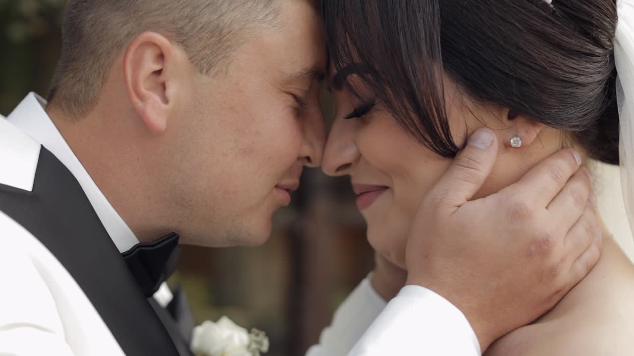recién casados, novio caucásico con la novia caminando, abrazándose, abrazándose en el parque, pareja de bodas enamoradas