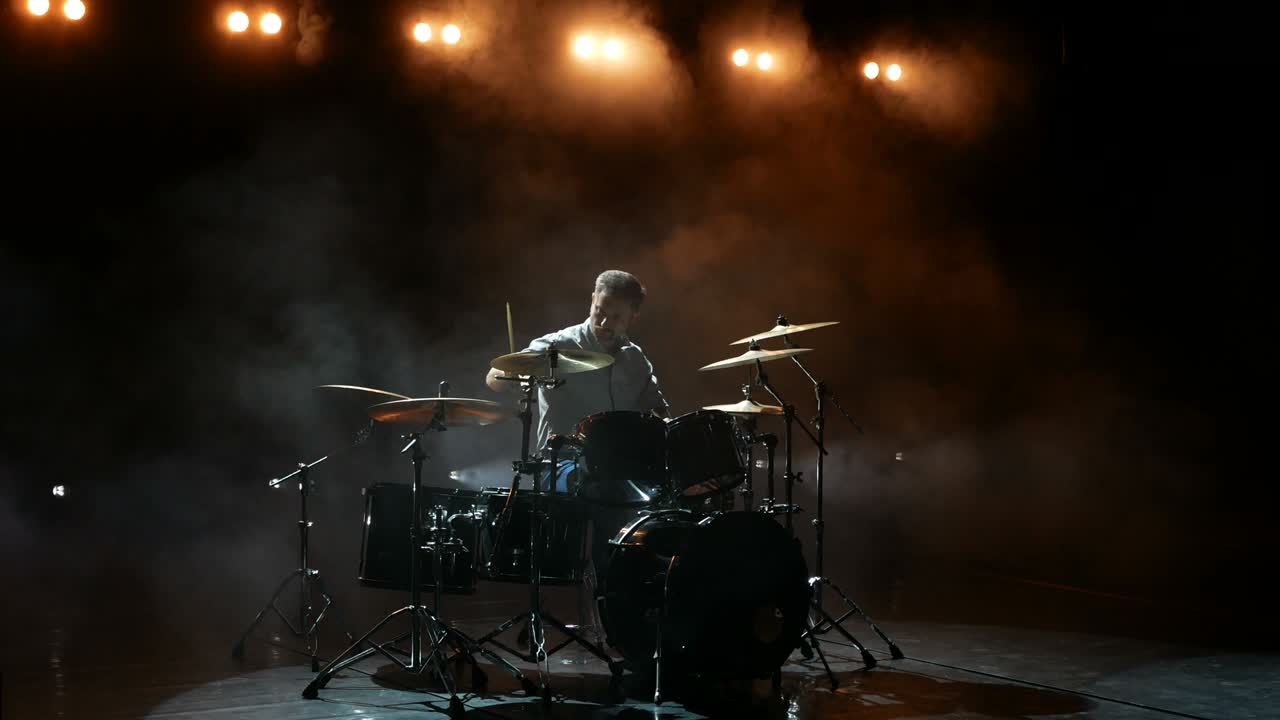 Il batterista si esercita con la batteria prima di un concerto rock. L'uomo registra musica con la batteria