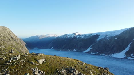 Un-Hombre-De-Pie-En-Un-Borde-Del-Glaciar-Tunsbergdalsbreen