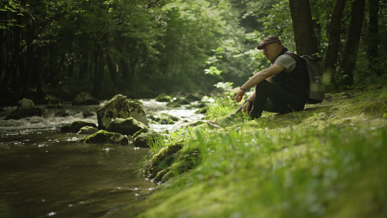 Man Relaxing by a River in the Forest