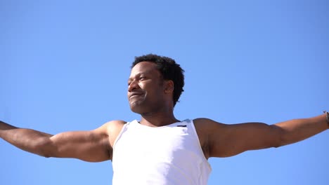 Hombre-Atlético-Sonriente-Entrenando-Contra-El-Cielo-Azul