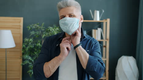 man adjusting face mask at home