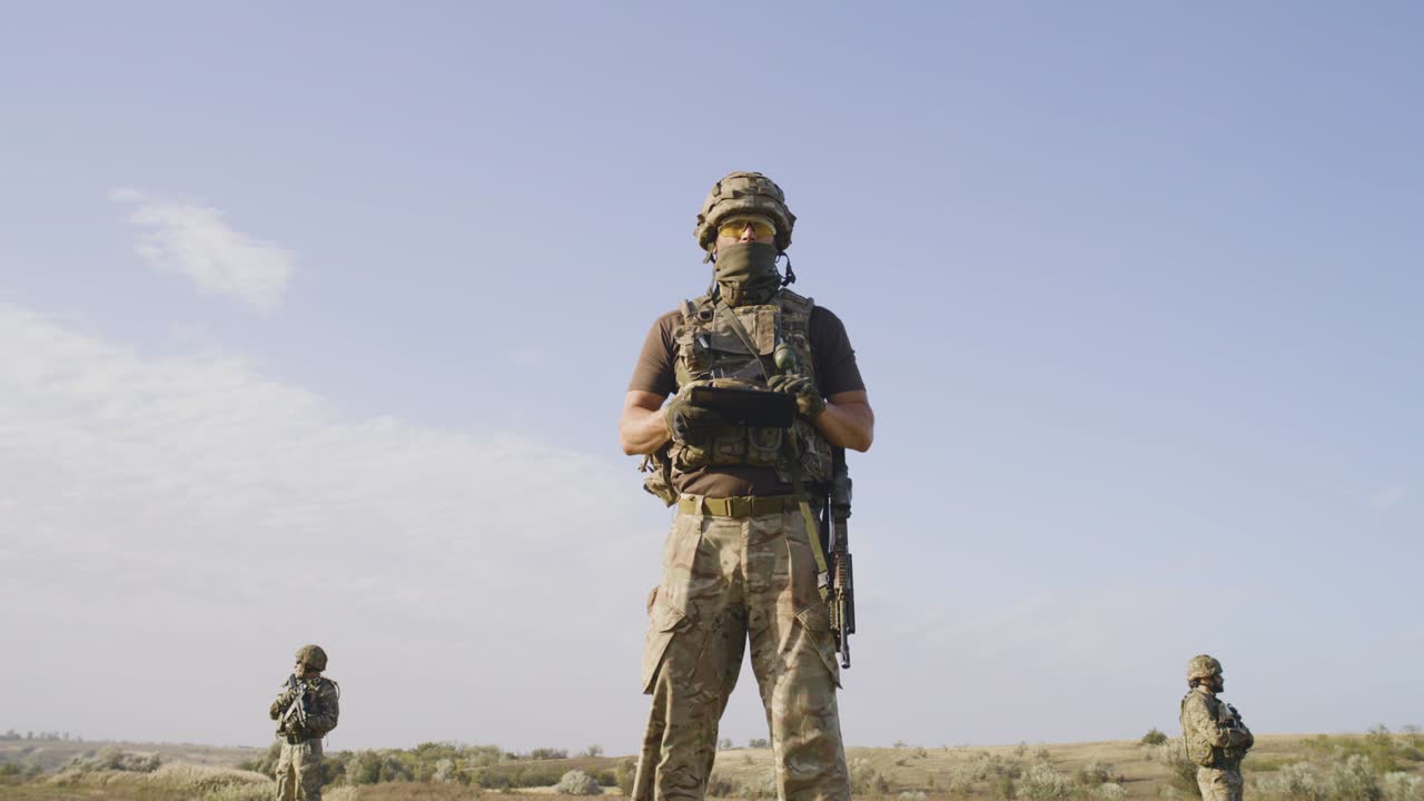 Men in uniform controlling field area and collecting data