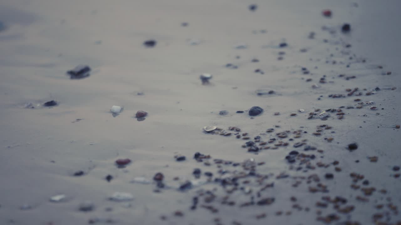 tiempo de la noche macro agua chocando en la playa con hermosas piedras pequeñas