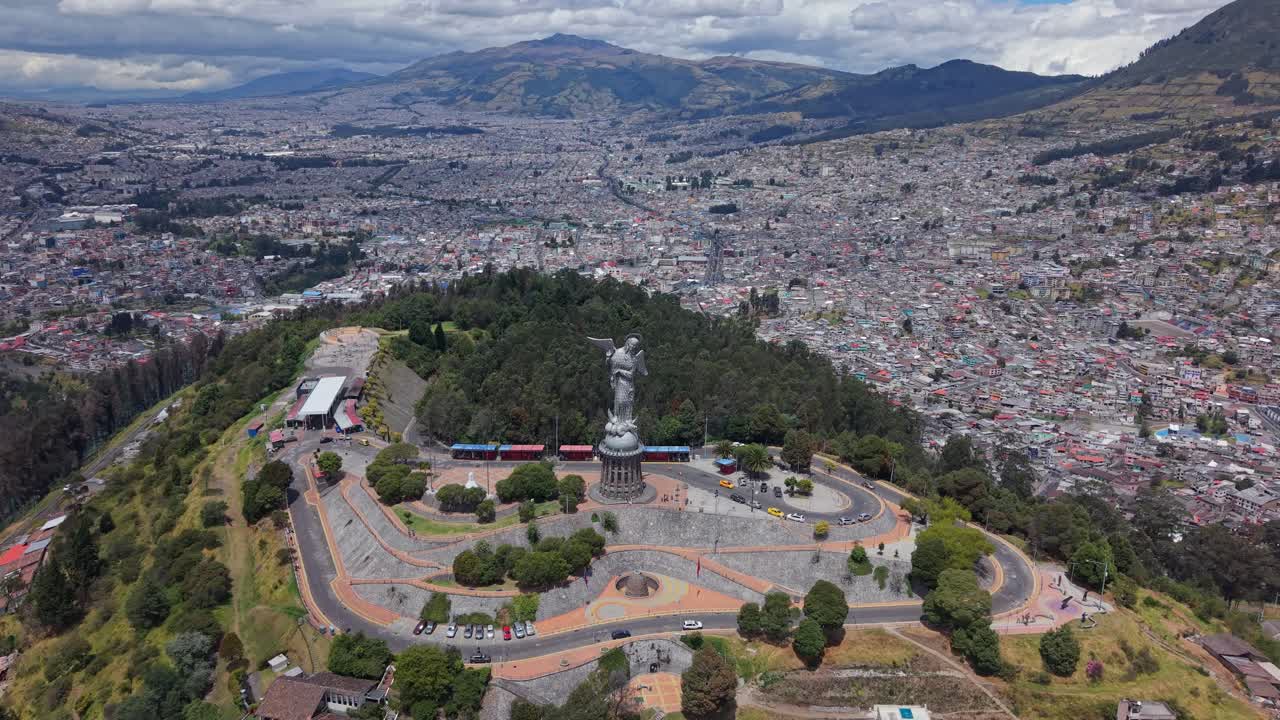 Um drone se afasta da Virgem de Quito em um dia nublado, revelando a vasta cidade, as montanhas e a história de Quito abaixo