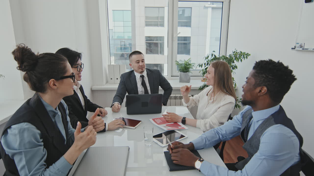 Team of Businesspeople High-Fiving in Meeting Room