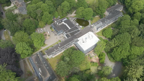 high angle aerial of beautiful hotel and conference center in the middle of green forest