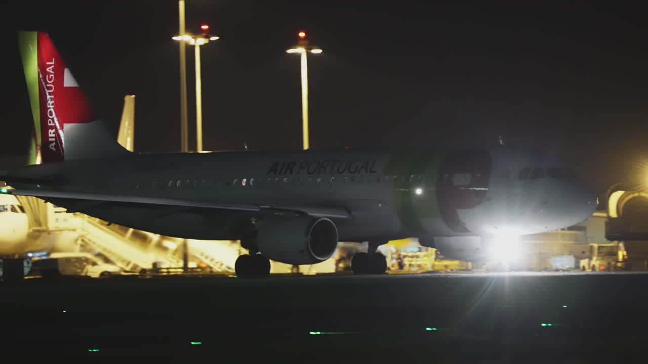 Aereo TAP Air Portugal sul piazzale di notte con un secondo aereo TAP visibile