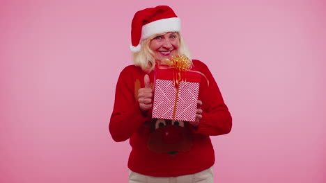 Abuela-Mayor-Con-Suéter-Y-Sombrero-De-Año-Nuevo-Presentando-Caja-De-Regalo-De-Navidad,-Vacaciones-De-Venta-De-Compras