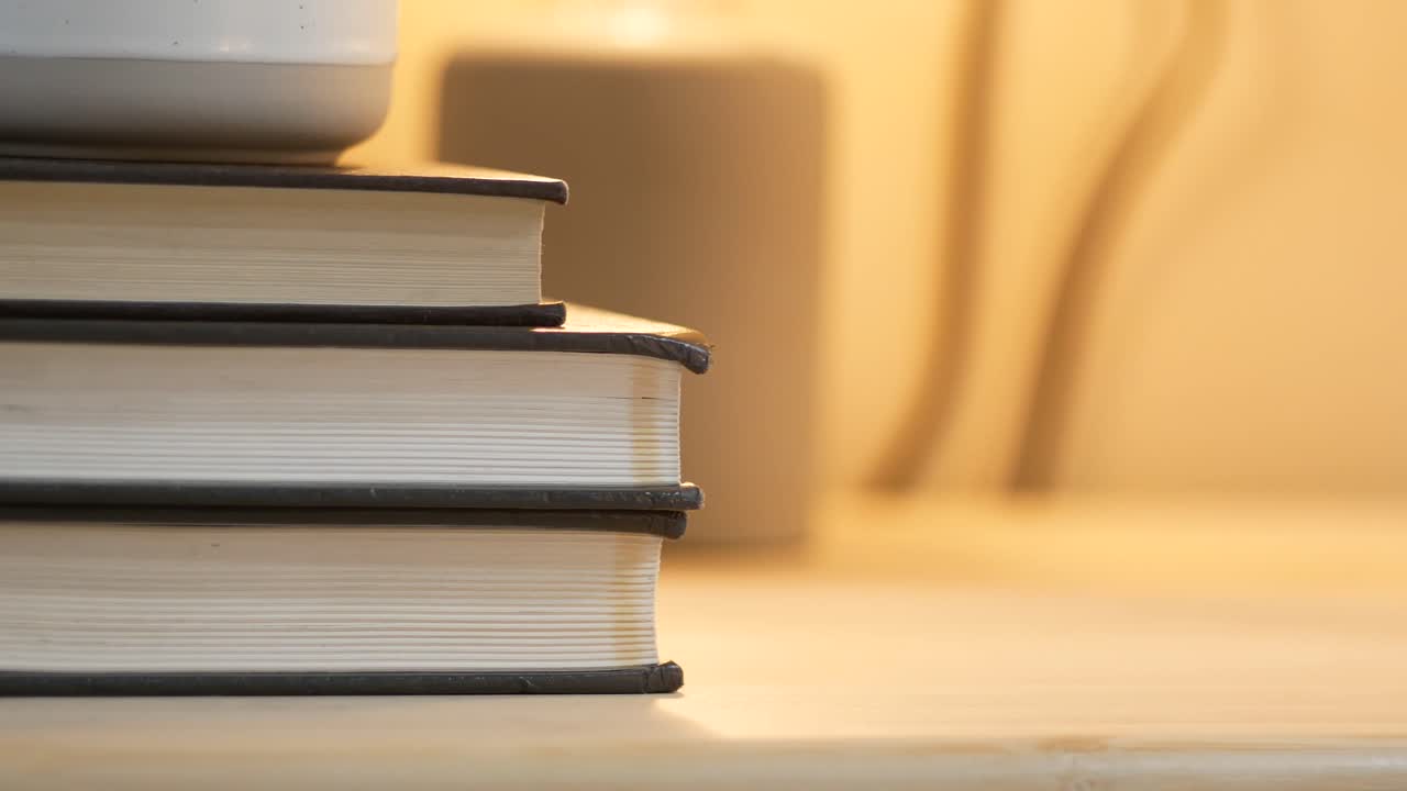 pila de libros con una taza y una vela