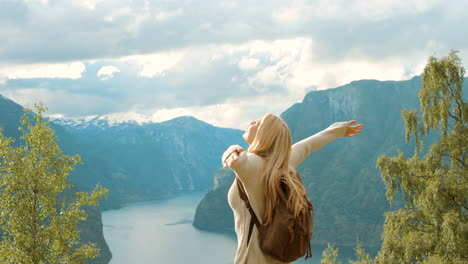 mujer disfrutando de la vista de un fiordo noruego