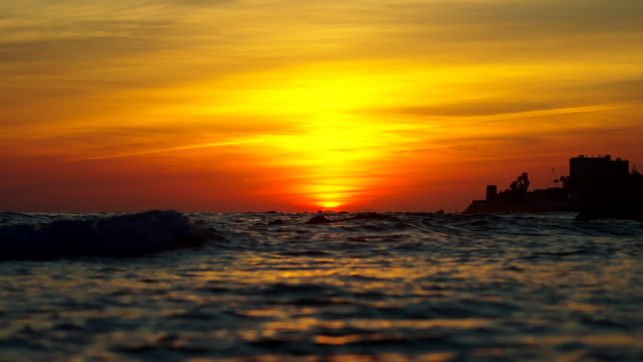 Dramatisk solnedgang med havbølger