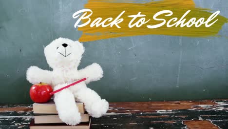 Back-to-school-text-over-teddy-bear-against-black-board