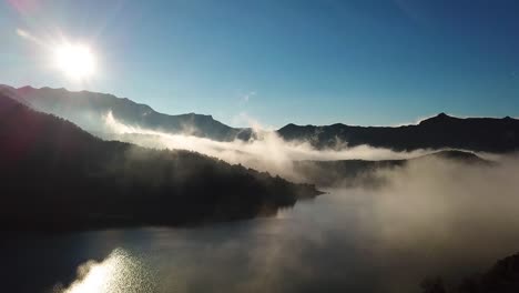 drone footage over a lake with fog over the water