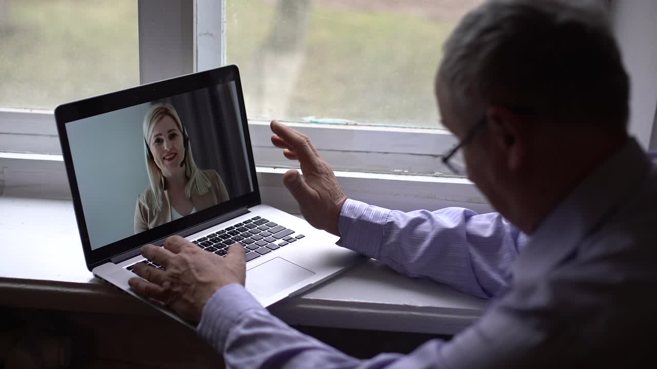 un anciano utiliza una llamada de video en su teléfono inteligente para comunicarse, comunicarse de manera segura con la gente a través de una llamada de vídeo