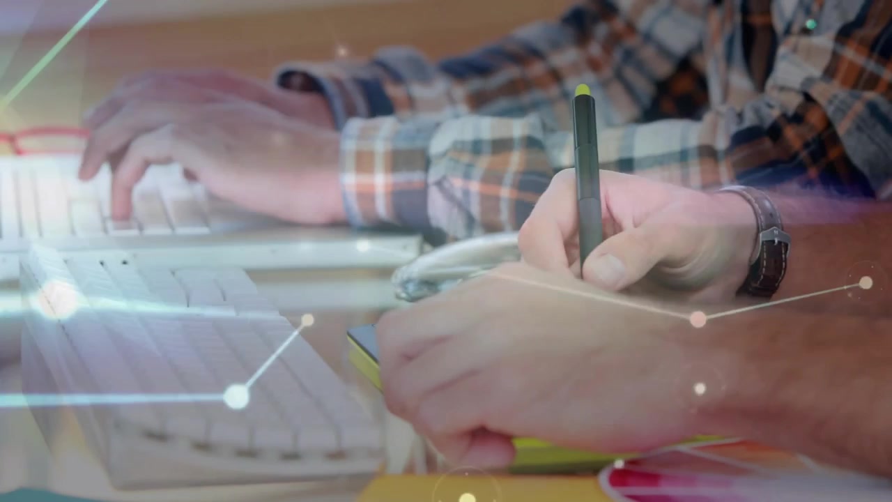Digitazione su tastiera che attiva un overlay di rete mentre un collega scrive su un blocco note con stilo nell'interfaccia utente dell'ufficio
