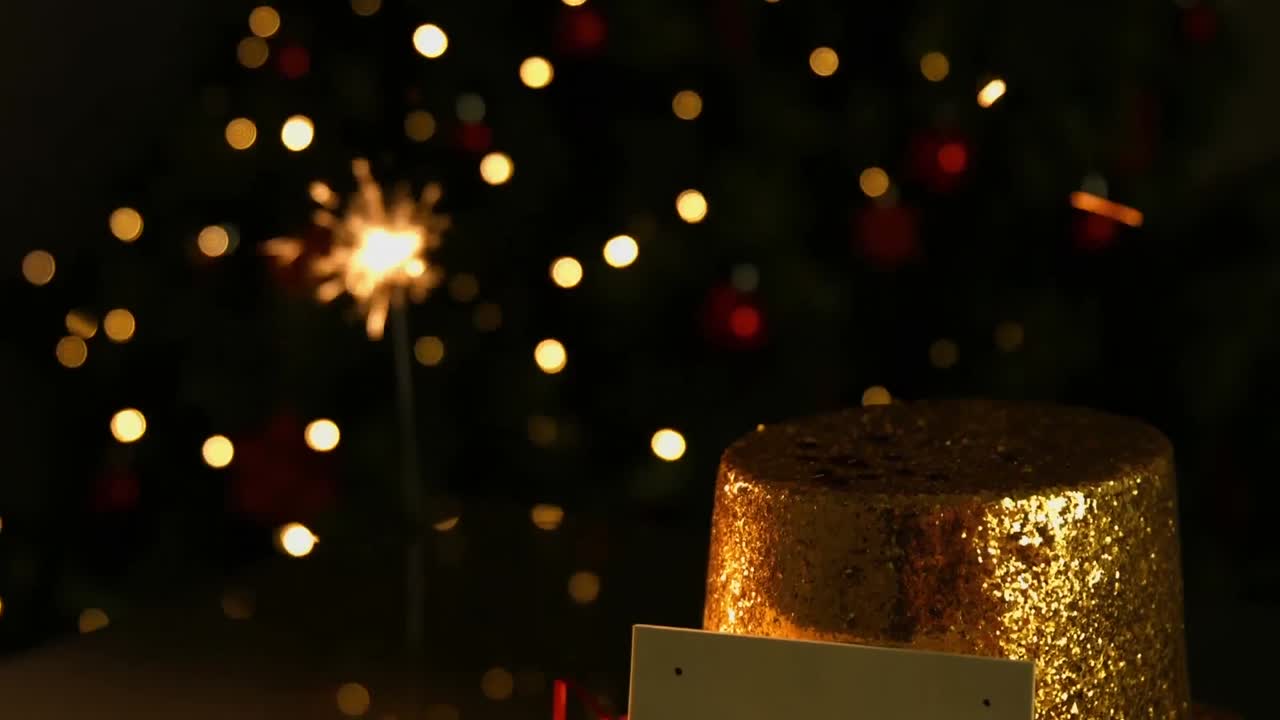 Animazione di stella filante, cappello di Natale e biglietto con spazio per il testo su macchie di luce arancioni.
