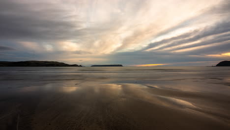 A-time-lapse-on-Plimmerton-beach,-located-north-of-Wellington-in-New-Zealand-with-a-view-of-Mana-Island-at-sunset