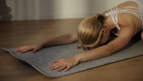 closeup of a woman doing yoga on a gymnastic mat stretching exercises closeup of a woman doing yoga on a gymnastic mat stretching exercises indoor yoga healthy lifestyle concept