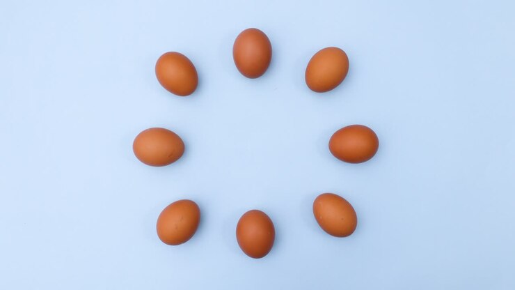 Eggs move in circle. creative dance moving of fresh eggs on blue theme. Stop motion