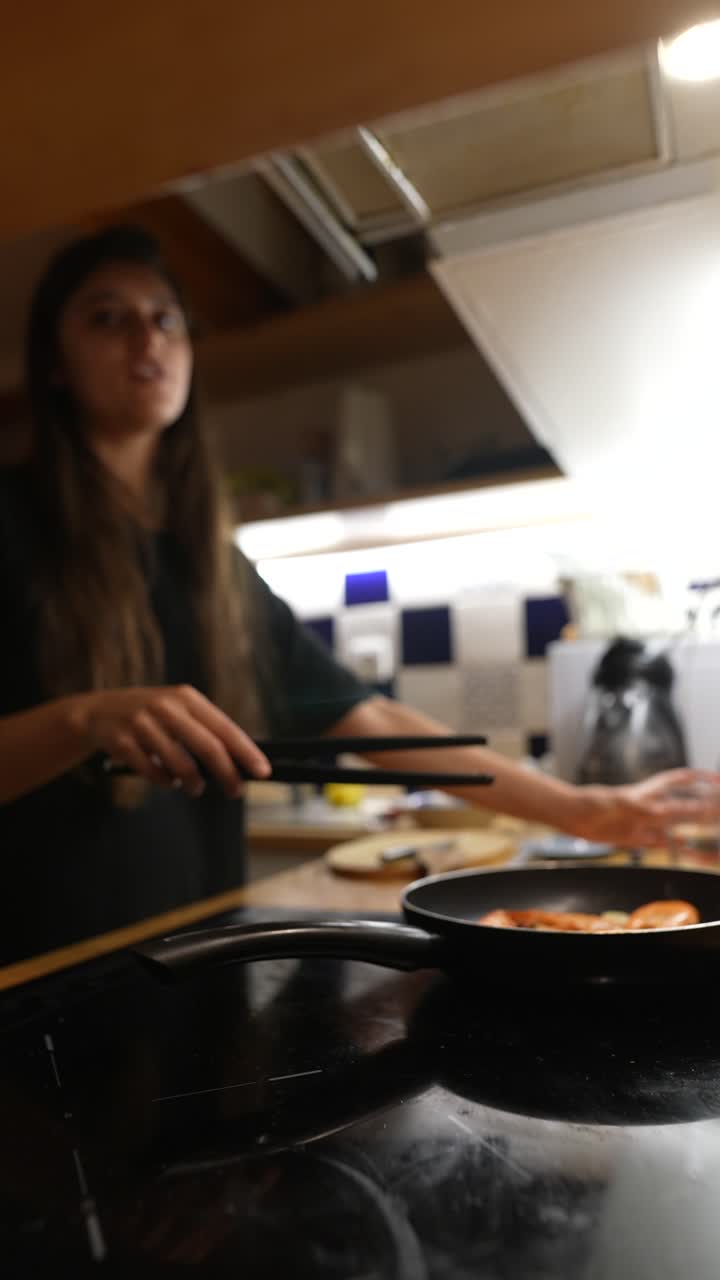 mujer cocinando cena de camarón en la cocina