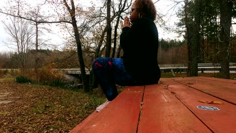 Young-black-woman-prays-on-a-park-bench-on-a-cloudy-day