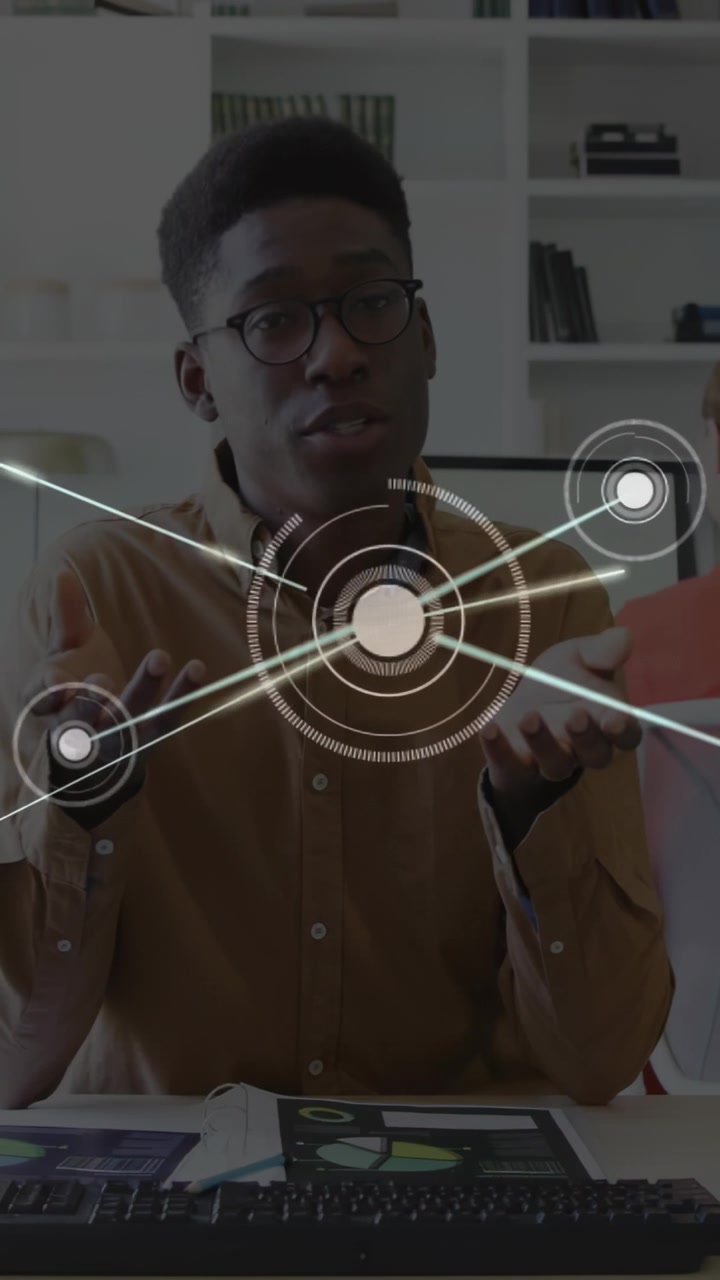 Vertical video: Tech analyst showing data to team, HUD rising over chest sparking nodes over chart