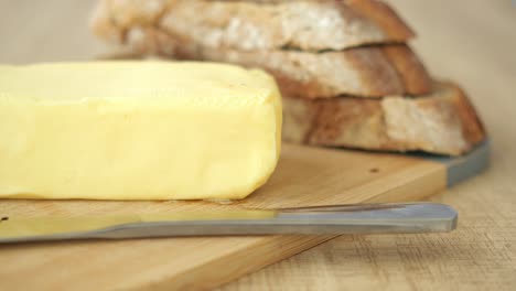 butter and bread on a wooden cutting board