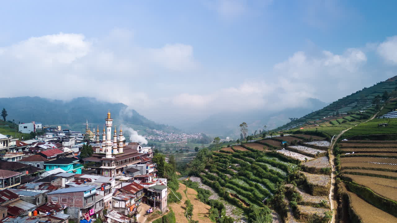 asentamiento de la ciudad de la ladera de la colina con mezquita decorativa en el valle agrícola montañoso