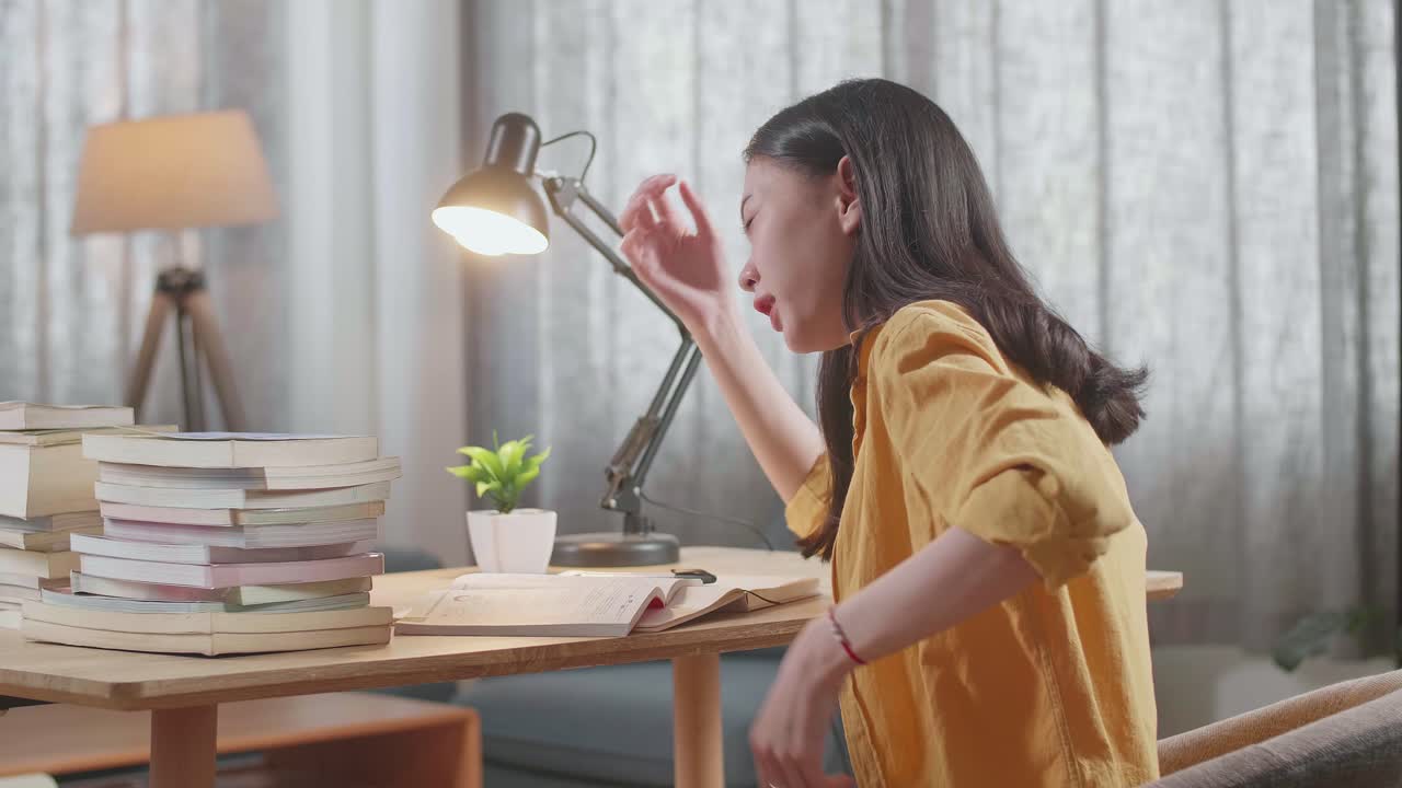 mujer con dolor de espalda mientras estudia