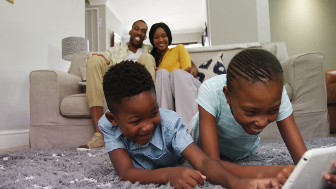 дети используют цифровой планшет, в то время как пара улыбается на заднем плане 4k