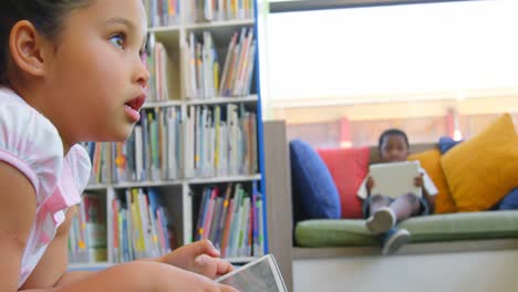 Schoolgirl-studying-on-digital-tablet-in-school-library-4k