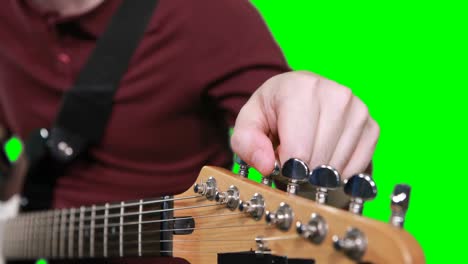 mid section male musician adjusting tuners