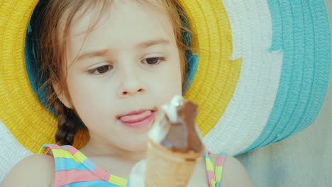 retrato de una linda niña en un sombrero que come helado de chocolate vacaciones de verano con niños co