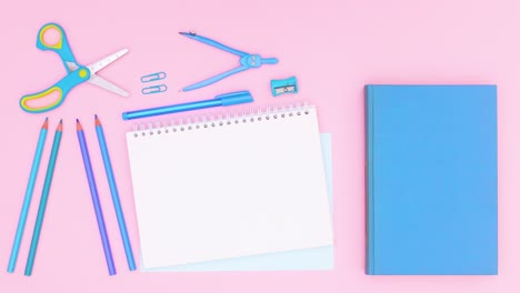 blue stationery moving around open notebook and blue book on pink theme. stop motion