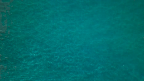 Rising-birdseye-view-of-therapeutic-open-ocean-green-blue-water-and-waves