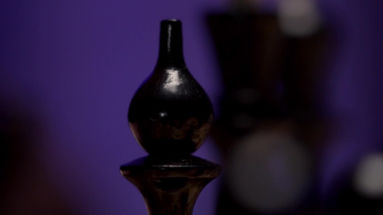 Hand Picking Up a Black Chess Piece