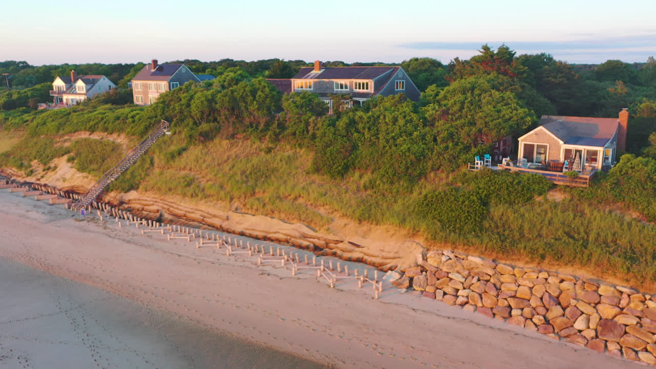 Riprese aeree con drone della Baia di Cape Cod: case fronte spiaggia con bassa marea e movimento discendente durante l'ora d'oro