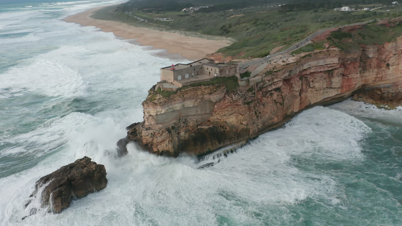 Beautiful aerial of Fort of São Miguel Arcanjo surrounded by a wild sea and high waves
