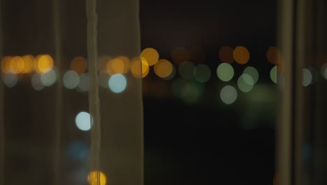 blurred background of night window with city lights with curtain