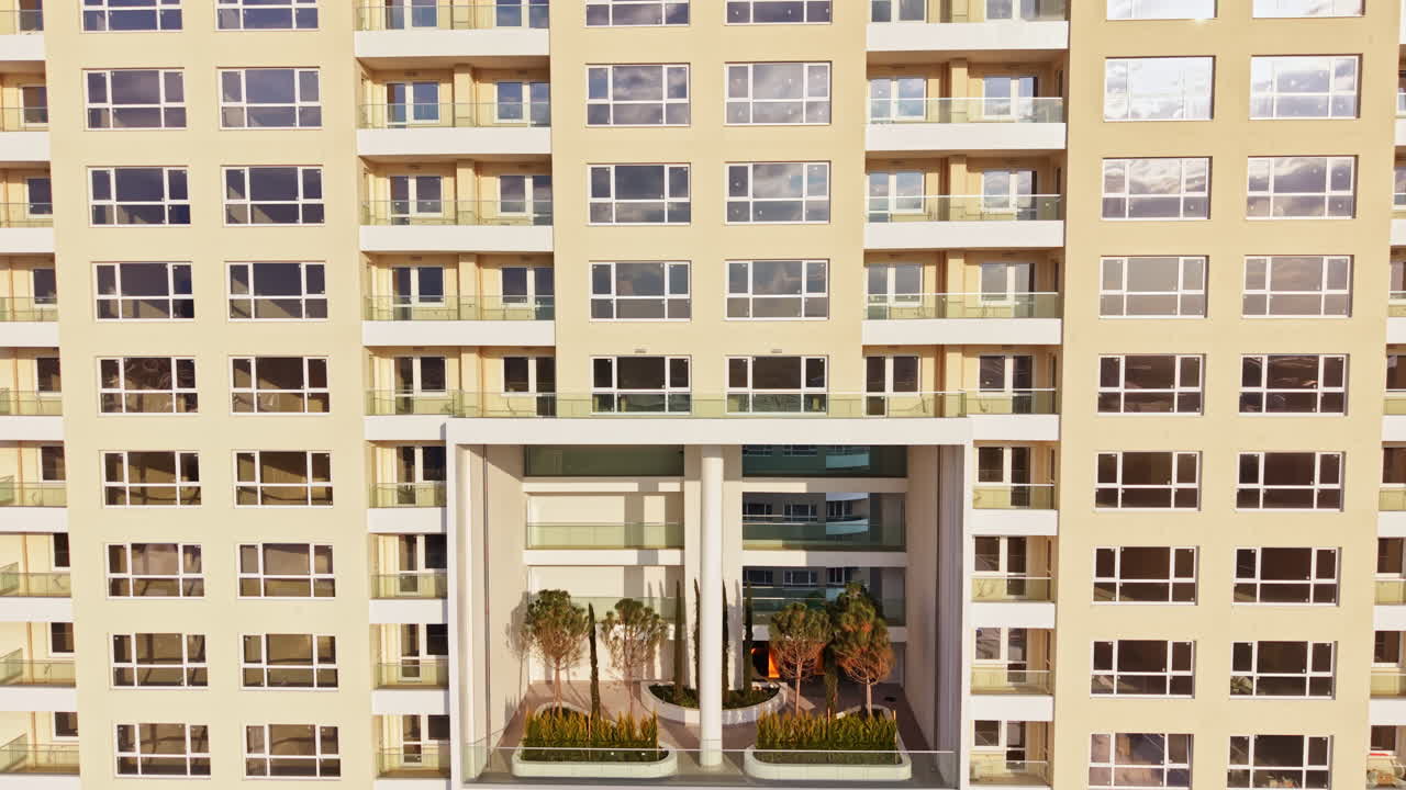 Moderne bygningsdesign viser en åben balkon med planter og træer i et boligområde om dagen.