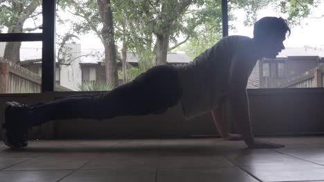 man doing push-ups in morning at home on back porch