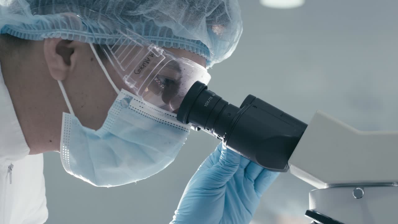 Lab worker observed with seeing a microscope in a research room