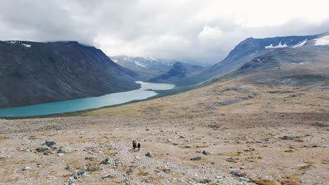 empuja el vértigo aéreo de un paisaje de valle de glaciar, lago de montaña, gente caminando en tiro ancho, camino de senderismo