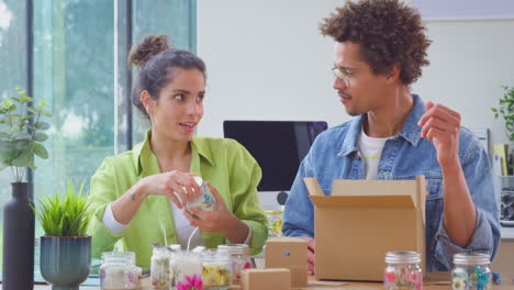 Pareja-Que-Dirige-Negocios-En-Línea-Desde-Casa-Empacando-Y-Etiquetando-Velas-Boutique-Listas-Para-Enviar