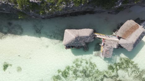 top down birds eye aerial view small wooden shack or house in ocean