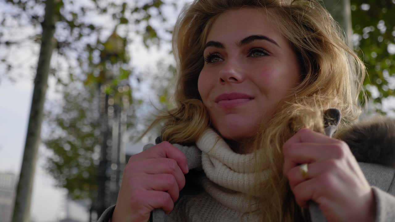 mujer de moda segura arregla su chaqueta en una fresca mañana de otoño