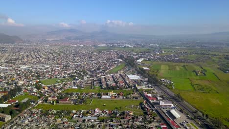 Top-drone-view-of-downtown-the-charming-town-of-chalco-Mexico,-and-view-of-the-downtown-and-roads-towards-Mexico-City