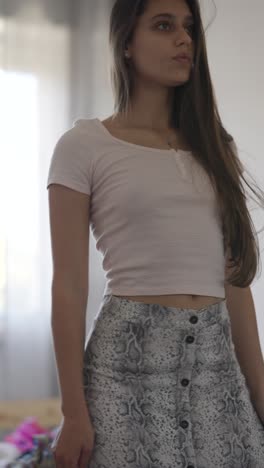 young woman in pink crop top and snake print skirt